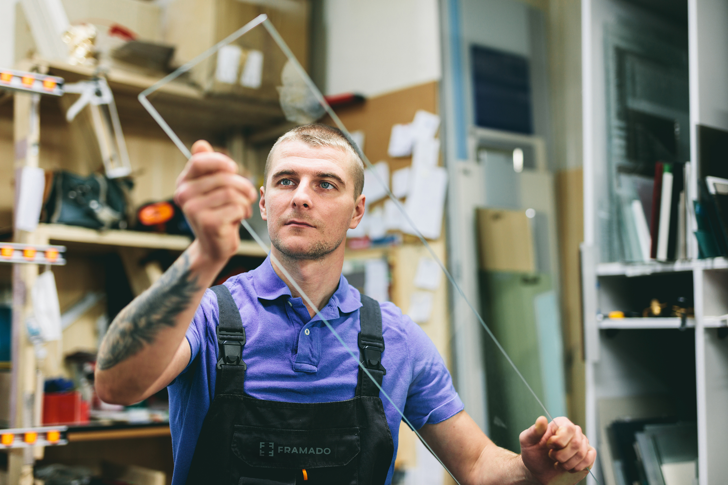 Glazier worker preparing glass in workshop. Industry and manufactory production